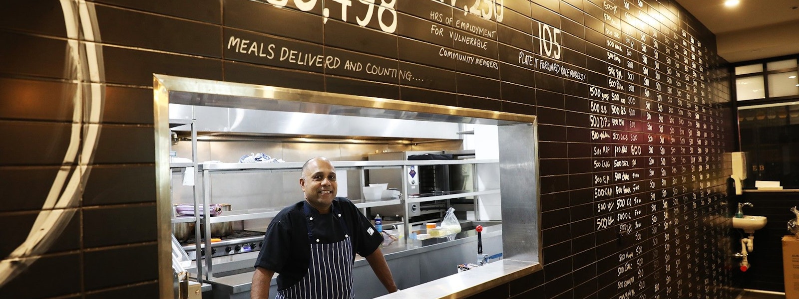 Man standing in hole in the wall cafe